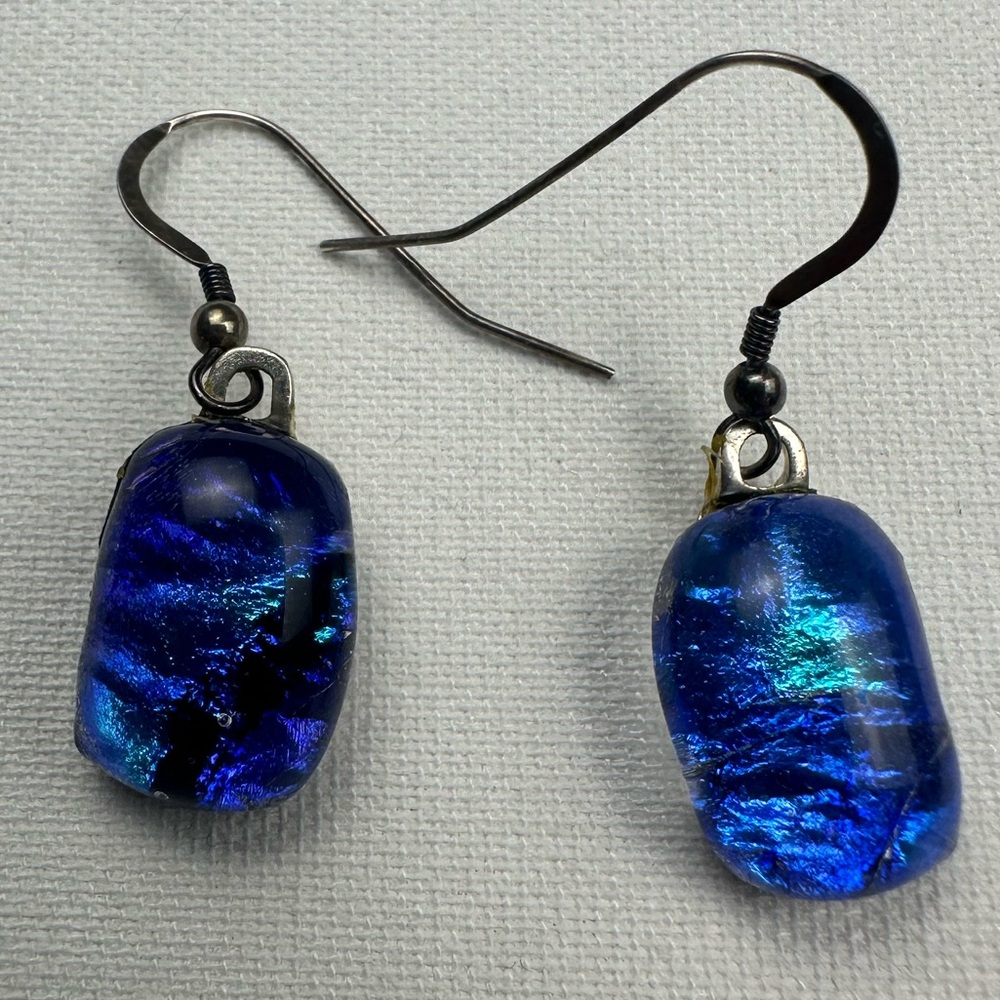 Deep blue iridescent bead dangle earring with silver hardware.